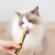 Kot jedzący kremową przekąskę UNIQ PETS PurrCream z tubki