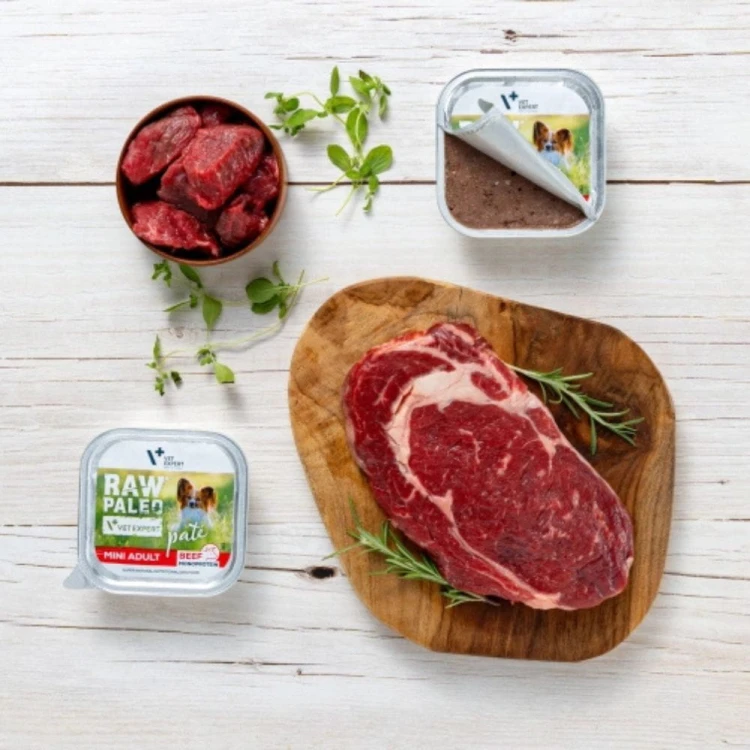 Vet Expert Raw Paleo Pate Mini Adult Beef 150 g obok kawałków wołowiny na drewnianej desce
