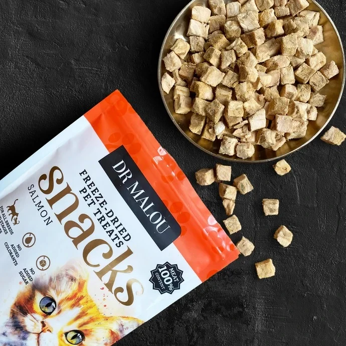 Dr Malou Snacks Salmon 50 g – opakowanie przysmaków z łososia obok miski z liofilizowanymi kostkami